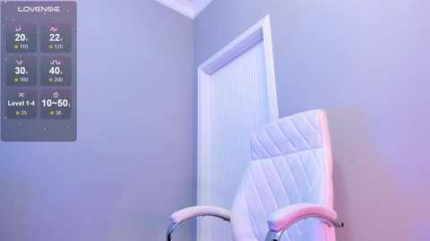 A video of a cozy, well-lit room with a white, padded chair and a light gray wall, featuring a digital display showing temperature levels and icons.