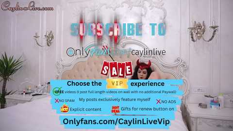 A promotional image for a live cam show featuring a woman in a devil-themed costume with red horns, seductively leaning against a plush, white tufted headboard in a luxurious, ornate bedroom.