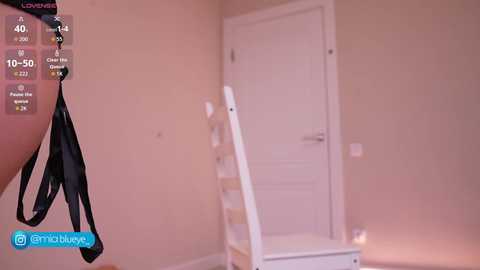 Video of a beige room with a white door and a black ladder on the left, a digital interface showing \"40\" and \"50\" in the top left corner.