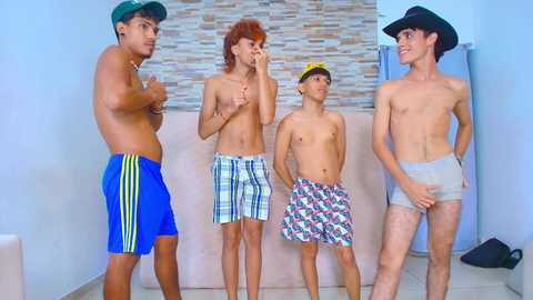 Video of four shirtless, fit young men in swim trunks, wearing cowboy hats, standing in a modern, tiled bathroom with a stone wall backdrop.