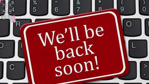 Media: Video of a red sticker with white text \"We'll be back soon!\" placed on a black keyboard. The sticker has a glossy finish and is centered on the keyboard.