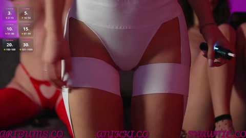 Video of a close-up of a woman's thighs in white panties, partially visible, with a blurred background and digital clock showing 3:15.