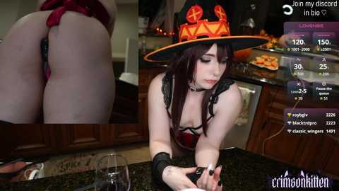 Video of a pale-skinned woman with dark hair, wearing a red devil hat and a revealing black and red lingerie, bent over a kitchen counter, with a close-up of her bare buttocks on the left.