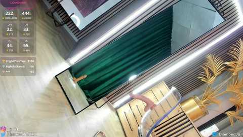 Video of a modern interior featuring a green curtain, wooden walls, a gold potted plant, and a staircase, with a digital interface displaying 2424 likes, 44 comments, and 54 shares.