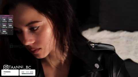 Media: A video of a young woman with fair skin, dark hair, and a black leather jacket, leaning against a dark background, wearing makeup, with a watermark indicating \"VANDANI BC\" and \"VANDANI\" logos.