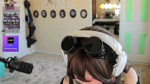 Video of a woman wearing VR goggles with brown hair, standing in a cozy, brightly lit room with a plush carpet, framed artwork, and a green door.