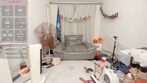 Video of a cluttered, messy room with a gray bean bag, a monitor, scattered items, a thermometer, and a partially visible calendar.