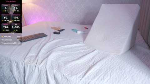 Video of a neatly made bed with a white comforter, a white pillow, and a remote control, displaying a \"Love Island\" TV show screen with a temperature gauge.