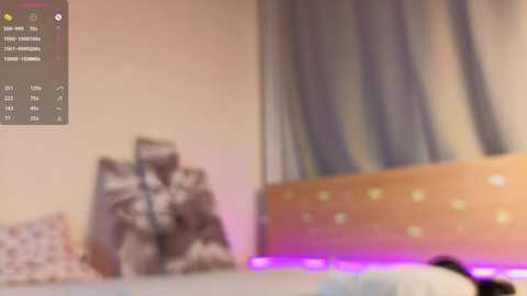 Blurry video of a person in a dark room, wearing a white t-shirt, leaning against a wall with a chart showing numbers and a graph.