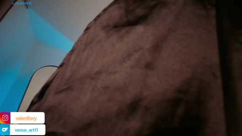 Media: Video of a close-up view of a man's muscular, hairy arm and shoulder, showing prominent veins and defined muscles. Background features a blue and white geometric pattern. Social media icons are visible in the lower left corner.