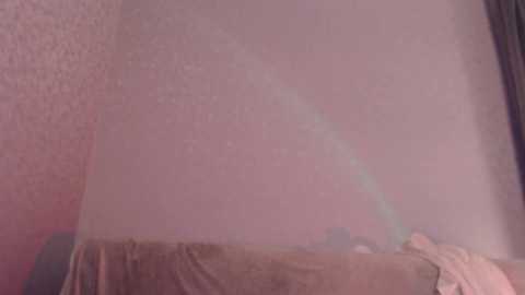 A video of a bare, pale-skinned arm with a faint rainbow-colored bruise on the upper arm, partially visible through a sheer curtain with a beige and white pattern.