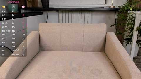 Video of a beige, fabric-covered armchair with a minimalist, modern design. The background features a white radiator and a leafy potted plant. A digital overlay displays a calendar with various dates and events.