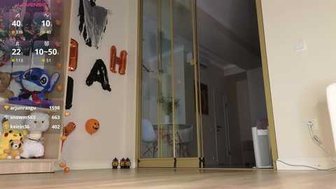 Video of a modern living room with a glass door, decorated with \"Halloween\" and \"Happy Halloween\" banners, featuring a plush Toy Story figure and a pumpkin.