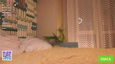 Video of a cozy bedroom with a white bed covered in a yellow blanket, beige curtains, and a small green plant. The room's decor includes floral wallpaper and a \"DMCA\" watermark.