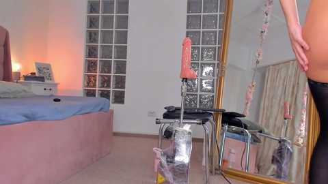 A video of a modern bedroom with a pink upholstered bed, a large mirror, and a chair with a pink vibrator.