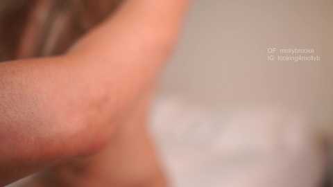 Close-up video of a light-skinned arm with visible veins, possibly male, in a soft-focus, blurred background. Text in German reads, \"Der Mythos: Ich habe keine Pickel.\