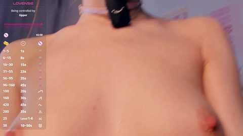 A blurry, low-quality video of a topless person with light skin and a black hair tie, featuring a digital overlay with temperature and heart rate readings.
