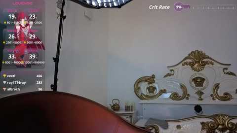 A video captures a luxurious bedroom with a gold-embellished white headboard, a red leather chair, and a large camera with a softbox on a stand. A digital display shows streaming and camera settings.