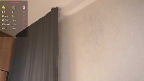 Video of a beige wall with a black curtain partially drawn, showcasing a wooden cabinet and a digital control panel displaying temperature and fan settings.