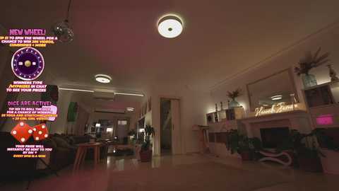 Video of a dimly lit, cozy living room with a plush, dark sofa, a large mirror, a TV screen displaying a colorful game interface, and various potted plants.