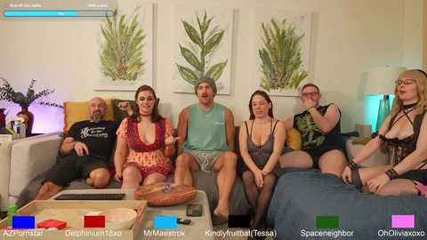 Video of a diverse group of seven people, including a bald man, sitting on a sofa, engaged in a video game, with a living room background.