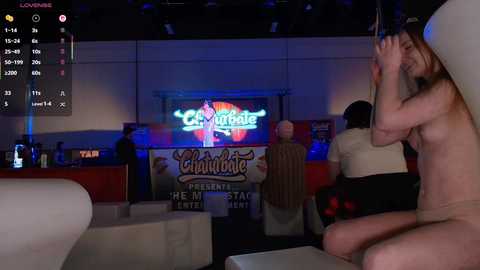 Video of a dimly lit nightclub featuring a nude woman dancing, a man holding a pole, and a bartender in the background.