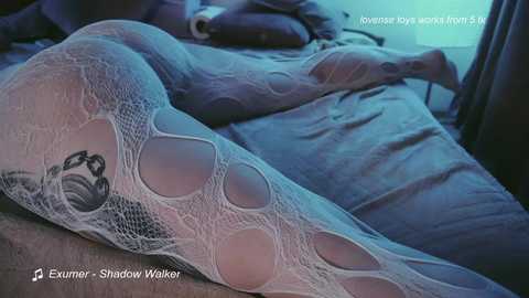 Media: Video of a woman's leg in white fishnet stockings with large circular cutouts, lying on a bed. Text overlays read \"Exercise toy: Shadown Walker\" and \"Overweight toy: Amy 5'6\" 180 lbs.\