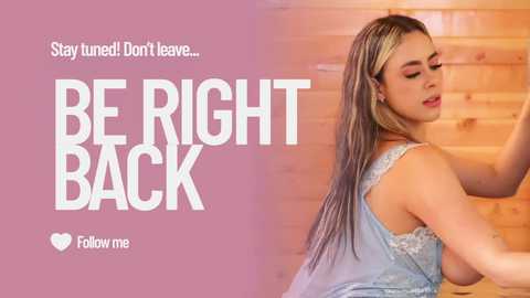 Video of a light-skinned woman with long, blonde-streaked hair, wearing a light blue, lace-trimmed top, sitting on a wooden bench against a warm wooden wall. Text reads, \"Stay tuned... Don't leave... BE RIGHT BACK... Follow me.\