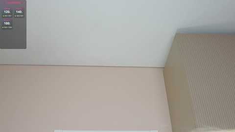 A video of a minimalist room corner showing a beige wall, a gray and beige textured rug, and a black-and-white digital display with numbers and a small logo.