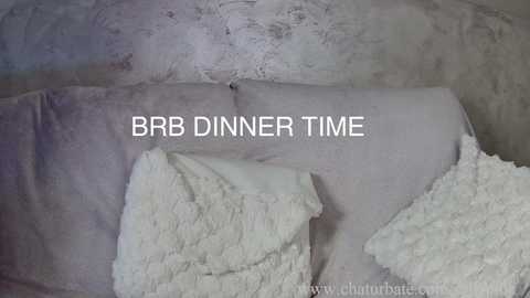 A video showing two white, fluffy towels draped over a textured, light gray concrete wall. The text \"BBB Dinner Time\" is prominently displayed in the center.