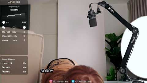 Media: Video of a person in a studio setting with a large white light source, a green plant, and a black light stand. Text reads \"LOVENBIE\" and \"SORRY.\