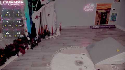 Video of a cozy, whimsical room with a large, plush bear, colorful pillows, and a white furry rug on light wooden floors. A neon \"LOVENSE\" sign hangs on the wall, and a calendar displays the date as 3/5/2022.