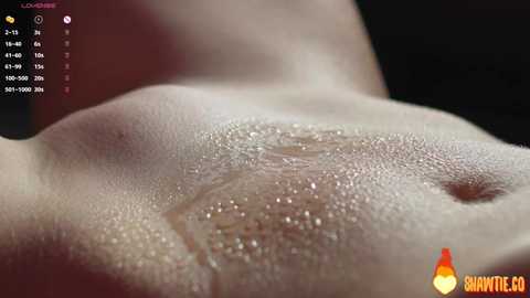 A close-up video of a nude, fair-skinned person's back and shoulder area, glistening with water droplets, against a dark background. A digital interface with temperature readings and a \"BANITY.CC\" logo is visible.