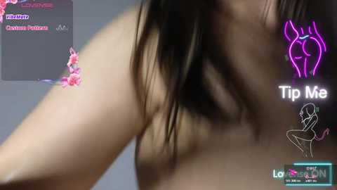 A blurred, close-up video of a woman's bare shoulder, with pink flowers and a neon pink 'Tip Me' sign in the background, indicating a live stream on Twitch.