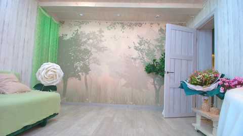 Video of a serene, pastel-themed room with a light green sofa, a large white rose sculpture, and a floral arrangement on a table. The walls feature a peaceful, forest mural.
