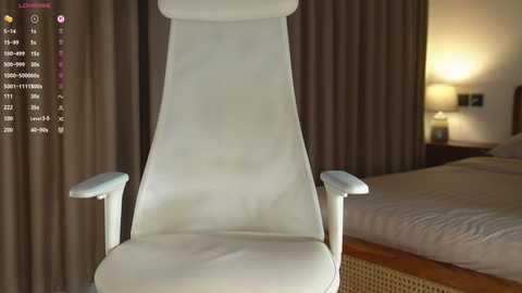 Video of a modern white leather recliner chair with armrests, positioned in a minimalist bedroom with beige curtains, a bed, and a warm-toned lamp.