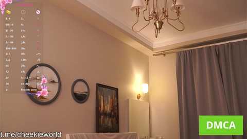 A video of a modern living room with beige walls, a chandelier, a large window with gray curtains, a round mirror, a clock, and a framed painting.