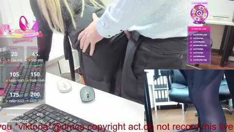 A video shows a woman in a white shirt, wearing a black skirt, sitting at a desk with a mouse and keyboard, with a video chat window displaying a man's face.