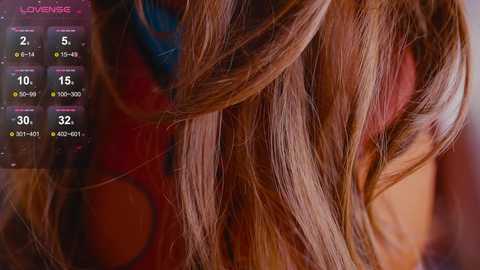 Video of a woman's brunette hair, with strands highlighted in a salon, featuring a digital interface displaying hair color options.