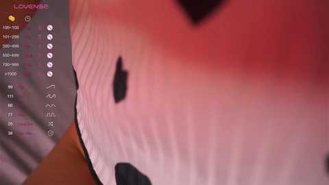 A close-up video of a person's lower abdomen, showing a large, dark mole on a light pinkish skin tone. The image has a gaming overlay with chat logs and a \"Lovenise\" watermark.