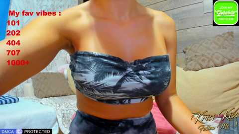 Video of a woman in a blue and white tie-dye crop top, showcasing her toned midriff and light skin. Background includes a couch with pillows, a blue wall, and a green and white \"My Favorite Vibe\" overlay.