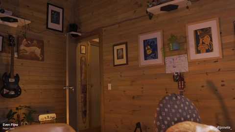 A cozy, rustic bedroom with wooden walls adorned with framed artwork, an electric guitar hanging on the wall, and a plush, patterned chair.