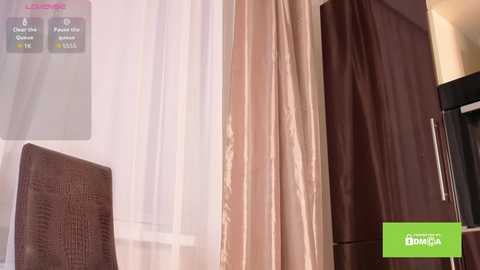 Video of a modern bedroom with beige curtains, a brown wooden wardrobe, and a textured brown chair, featuring a \"Lowe's Home Improvement\" logo and product details.
