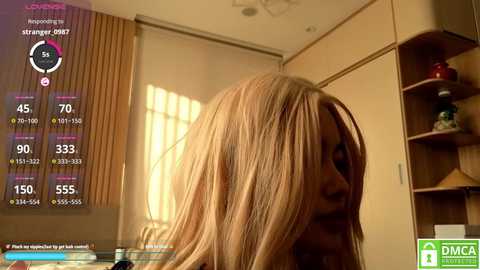 A video shows a blonde woman with straight hair, standing in a room with beige walls, wooden shelves, and a window. A smartphone screen overlay displays heart rate and temperature readings.