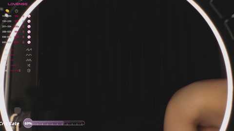 Screenshot from a video game, showing a black screen with a glowing circular outline, featuring a chat window on the left with text and symbols.