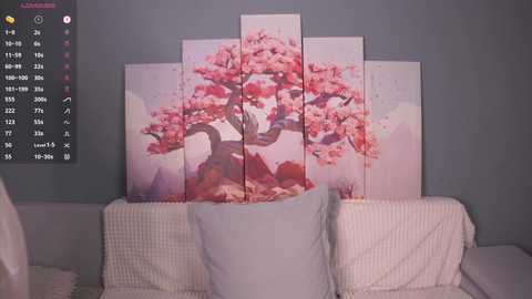 Video of a bed with a white quilt and pillows, featuring a wall-mounted artwork of cherry blossom trees in pink hues against a pastel blue wall.