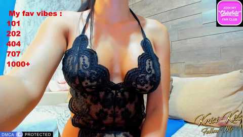 Video of a woman with light skin, wearing a black lace halterneck top, reclining on a bed with beige and blue bedding. Text overlays show user's profile and 1,007 views.