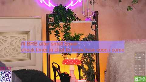 Video of a cozy indoor scene with a mushroom lamp, green plants, and a pink neon sign on a wooden shelf against a textured wall, overlaid with text in a purple overlay.