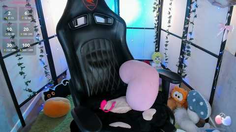 A video of a black gaming chair in a cozy, lit room with fairy lights, plush toys, and a cute teddy bear, giving a playful, comfortable atmosphere.