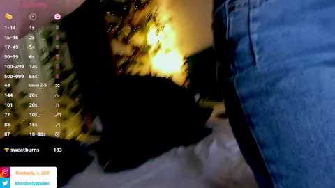 A video of a person's hand holding a black cat in a dimly lit room. The cat's eyes glow with a warm, yellow light, creating a striking contrast. The background shows a partially visible, cozy, indoor setting.